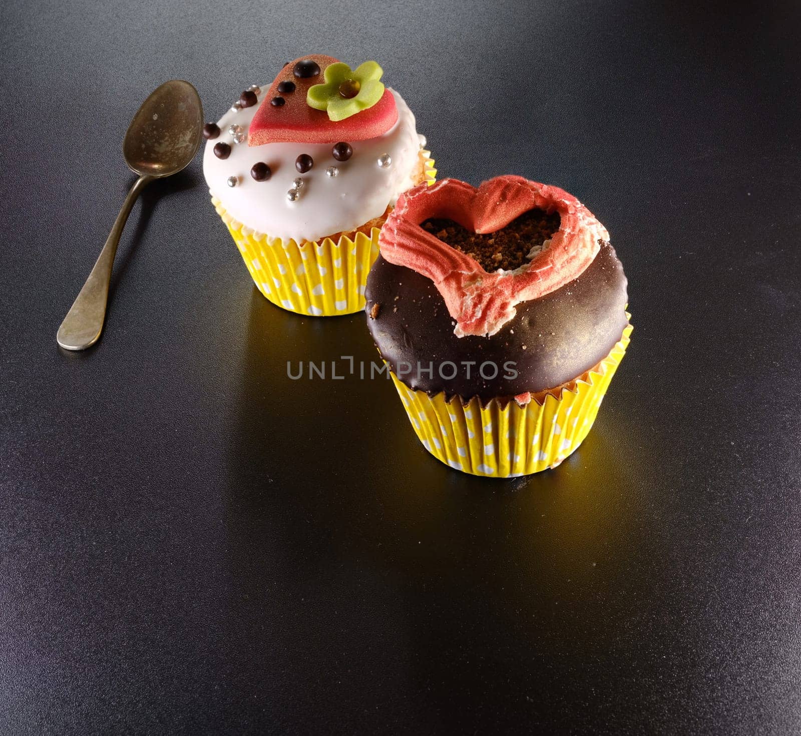 A delicious cupcake with heart on a black backround