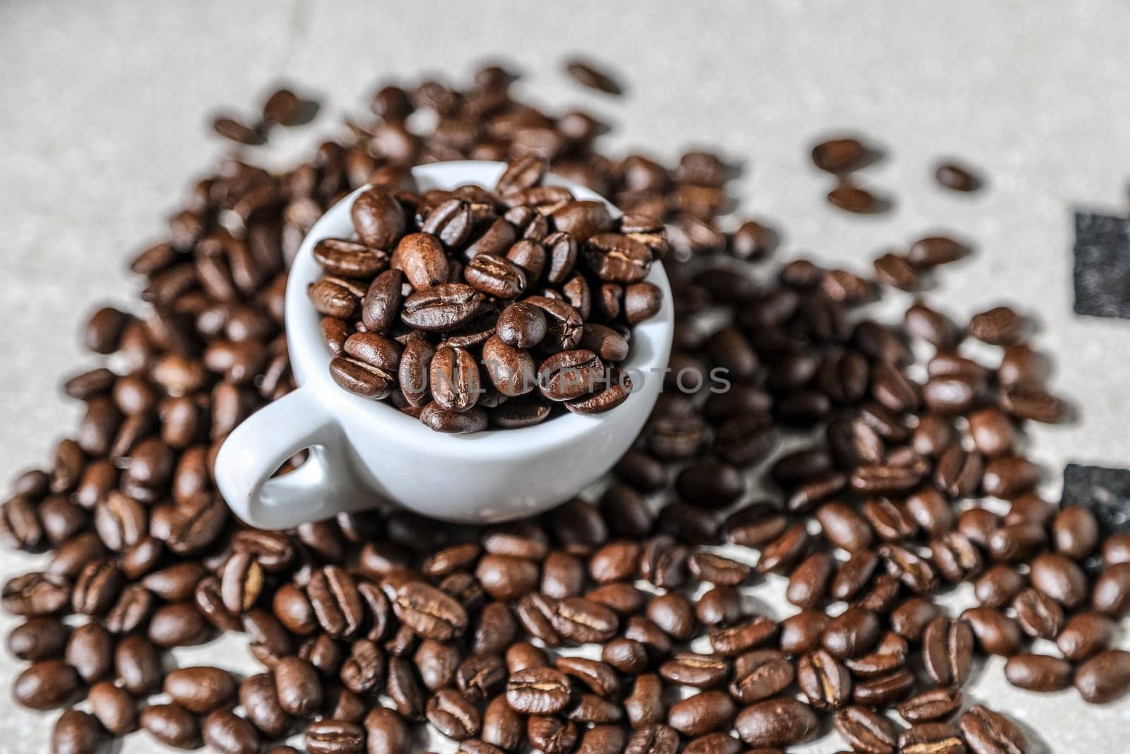 Close up of a cup of black coffee grains ad a cup