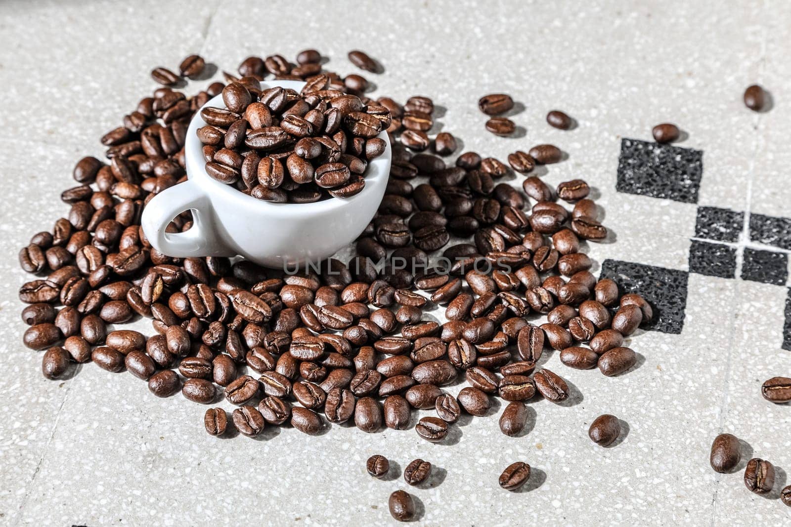 Close up of a cup of black coffee grains ad a cup