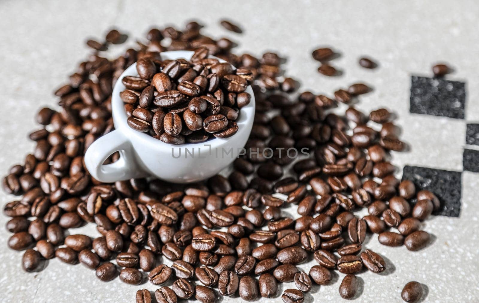 Close up of a cup of black coffee grains ad a cup