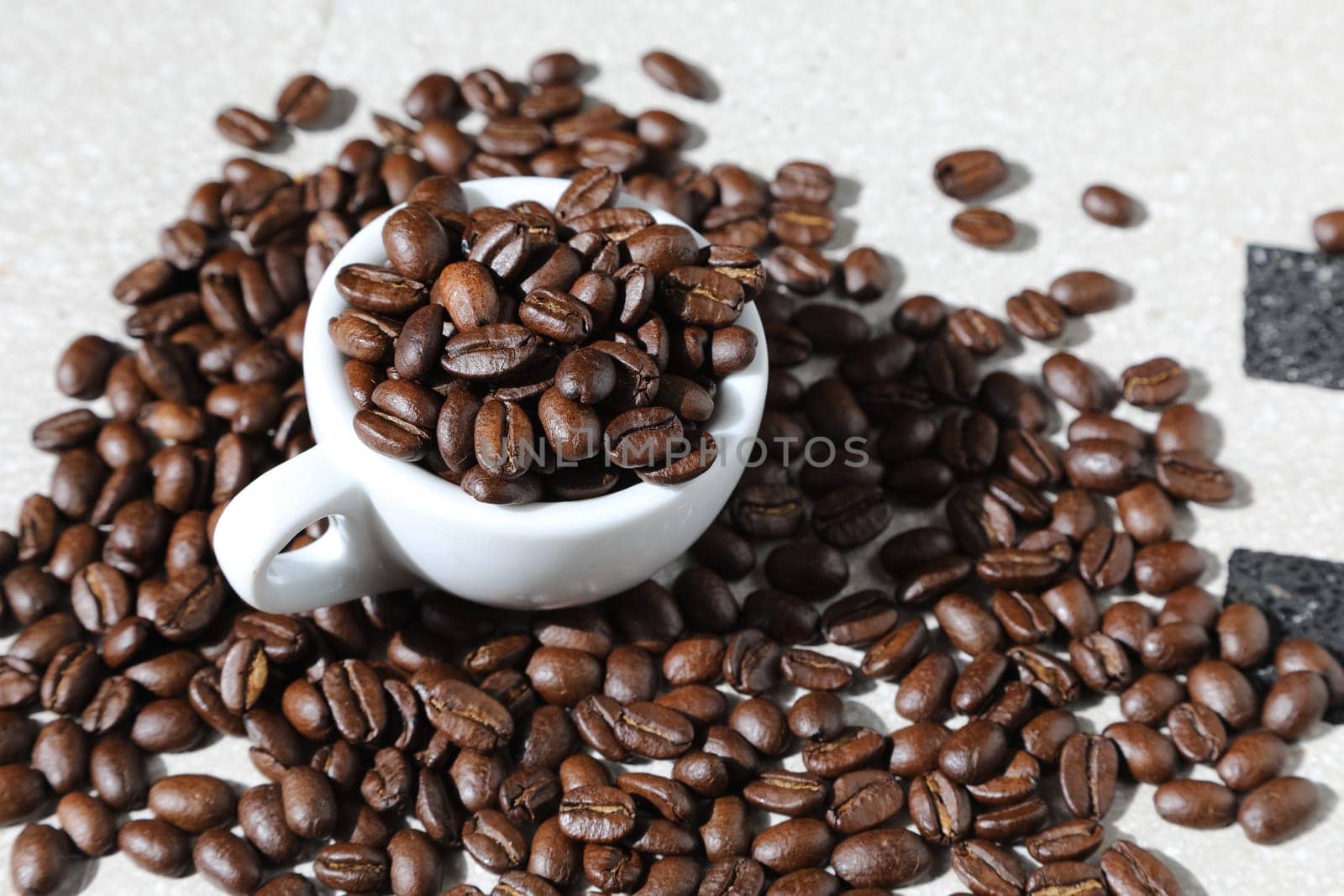 Close up of a cup of black coffee grains ad a cup