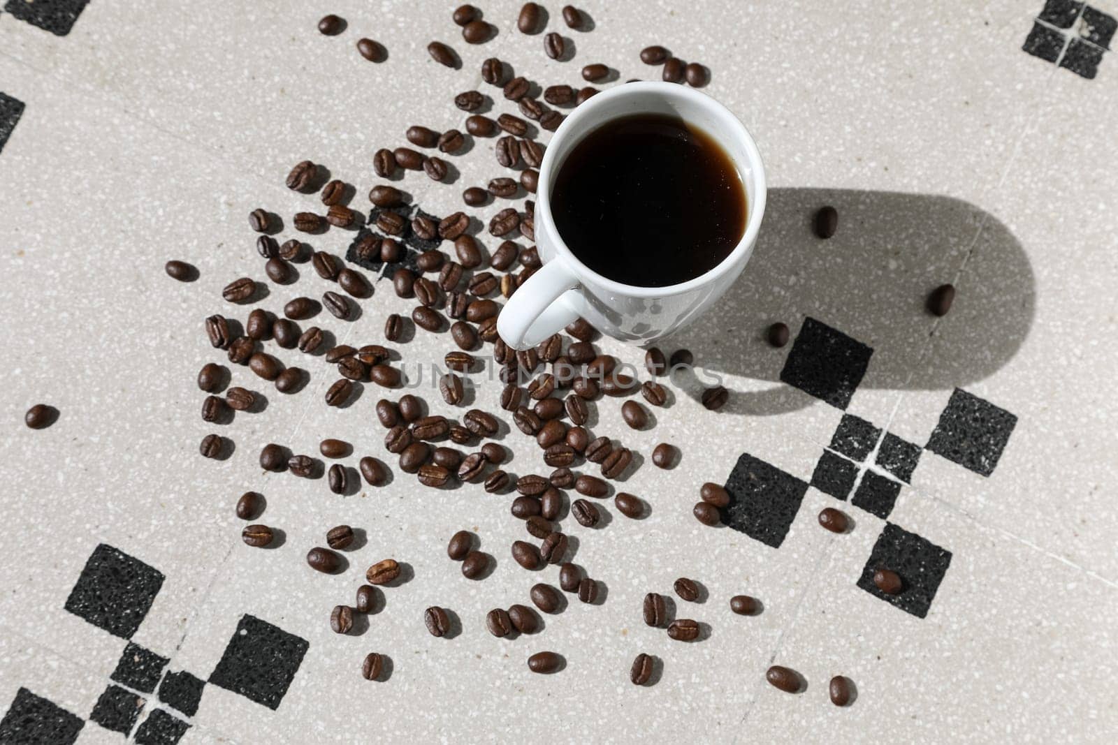 Close up of a cup of black coffee grains ad a cup