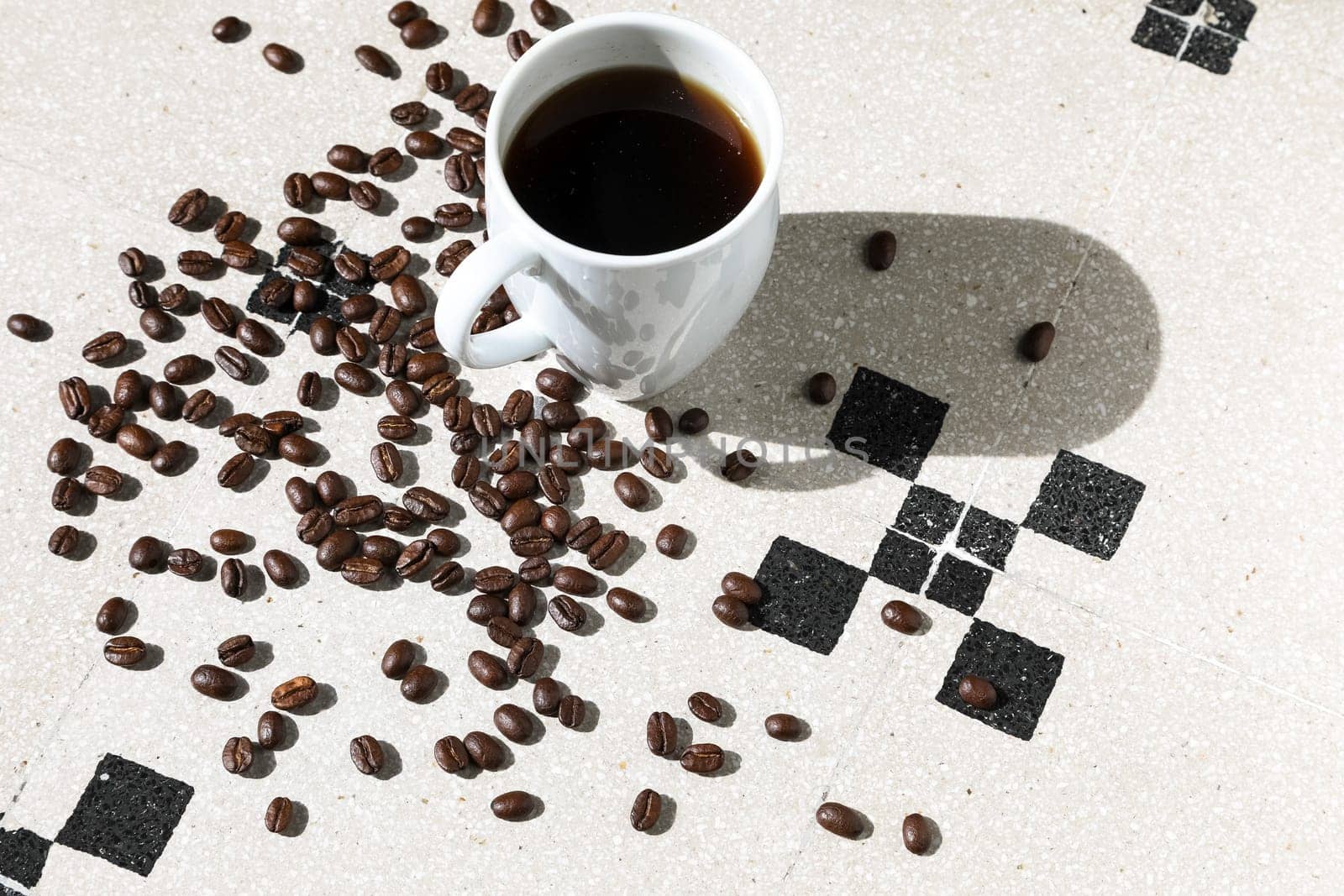 Close up of a cup of black coffee grains ad a cup