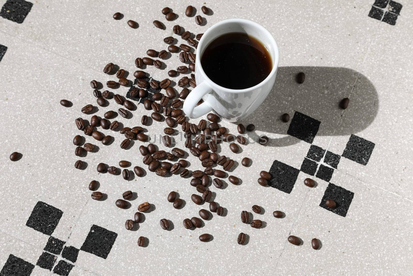 Close up of a cup of black coffee grains ad a cup