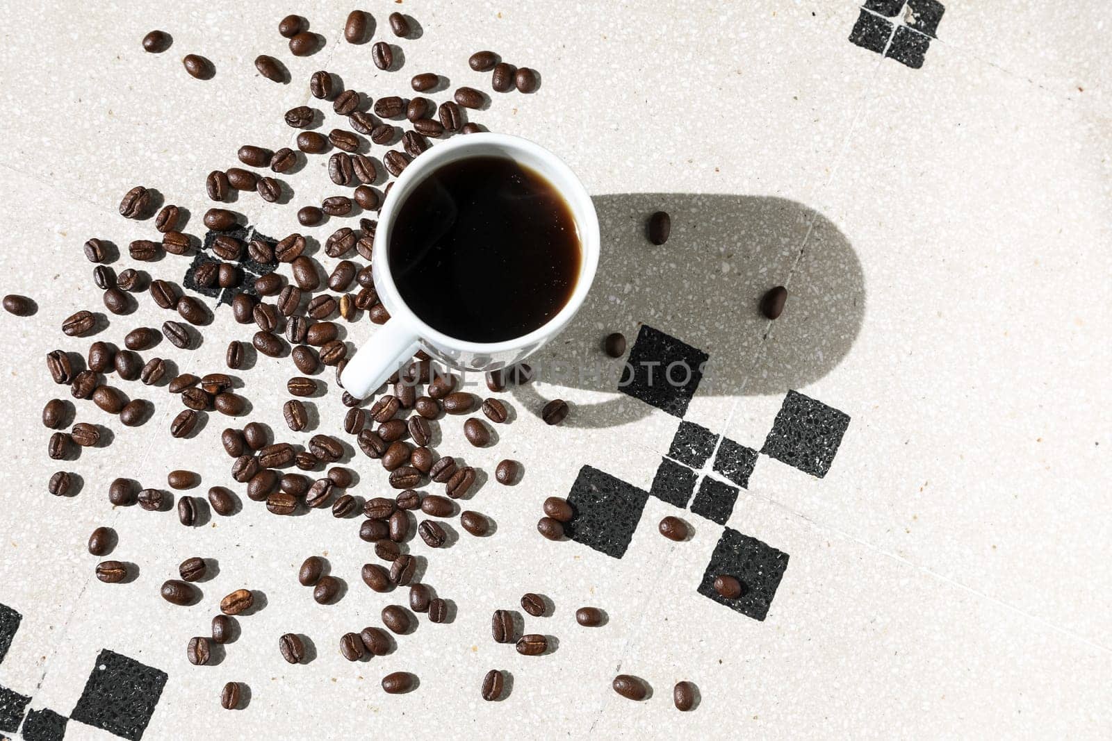 Close up of a cup of black coffee grains ad a cup