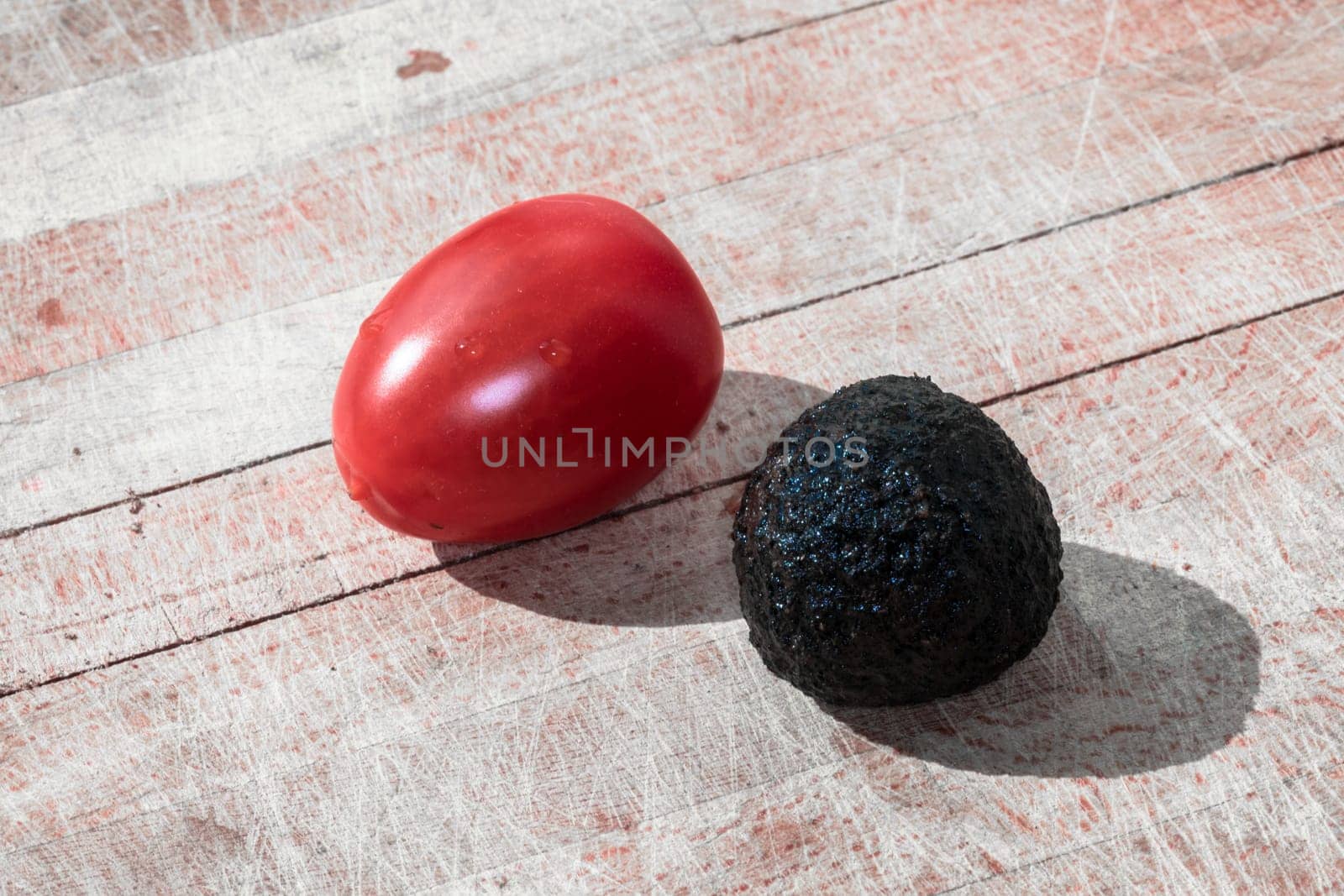 Tomato and black truffle isolated on a wooden cutting board