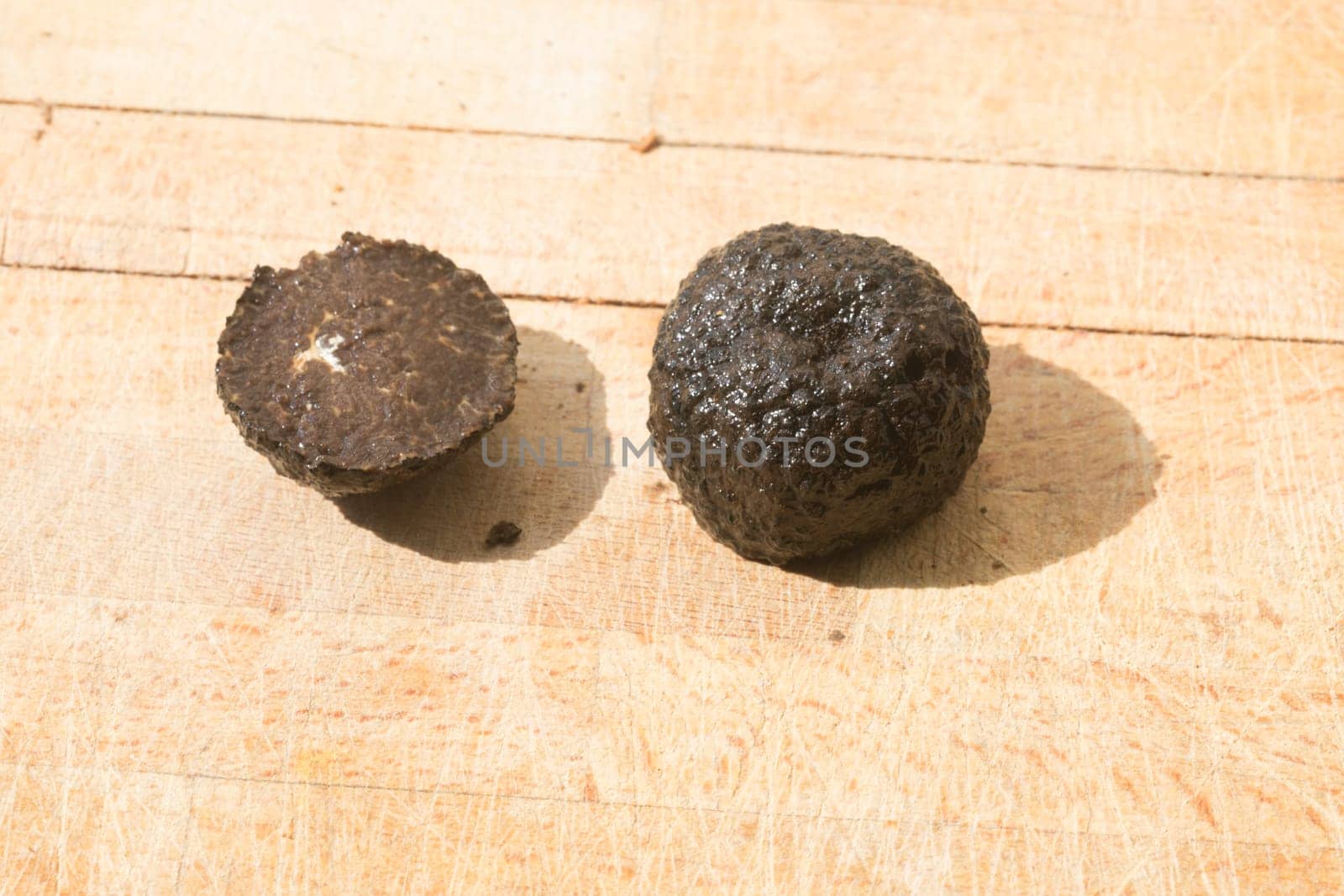 Tomato and black truffle isolated on a wooden cutting board