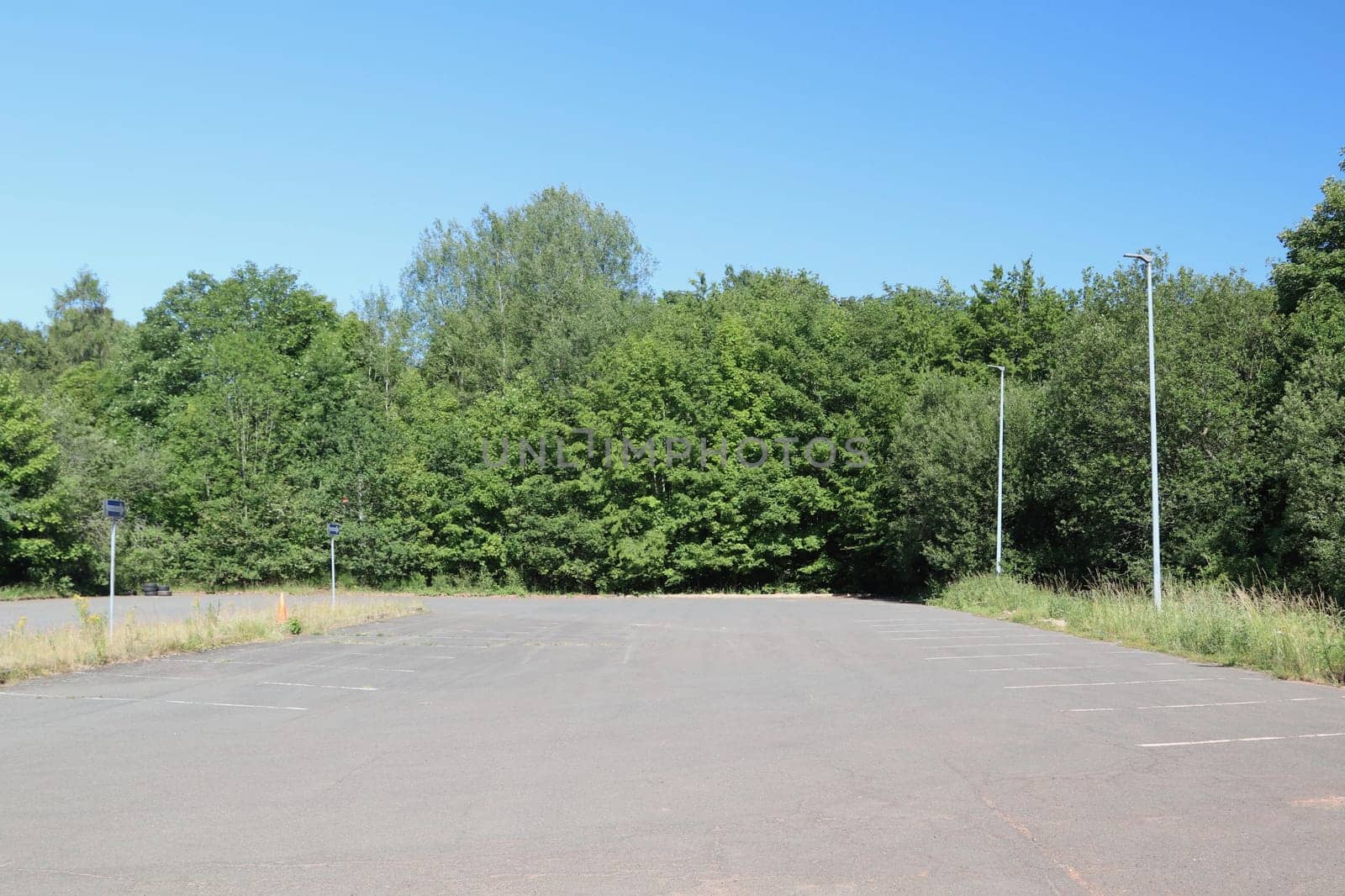A large parking lot with green trees in the background