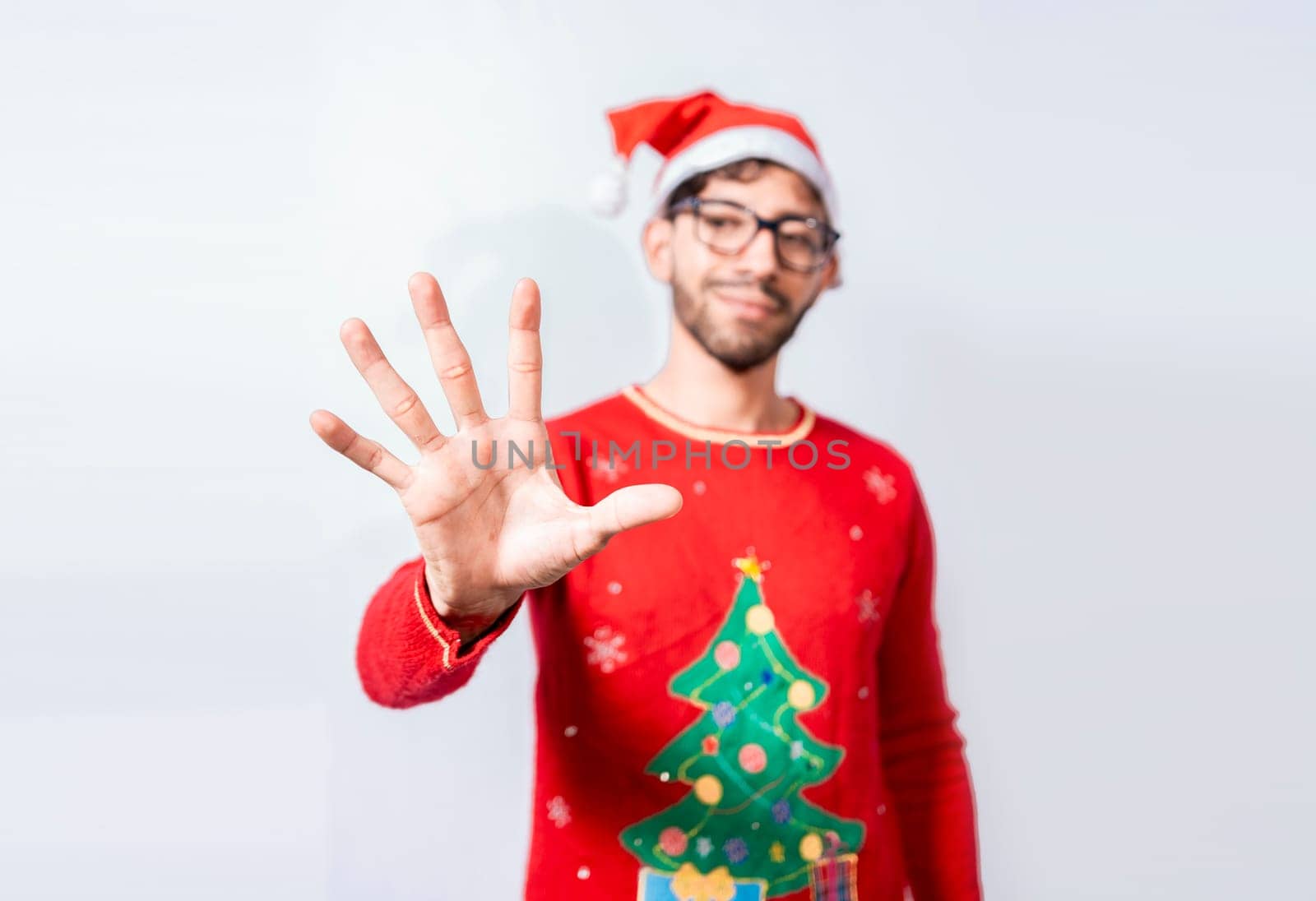 Man in christmas hat counting number five with fingers. Man in christmas costume counting number five with fingers. Concept of man in christmas costume counting number five isolated