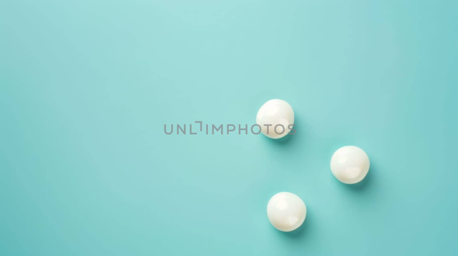 Three white pills are arranged neatly on a bright blue background, creating a simple and clean composition. The pills are round and smooth, with a glossy finish.