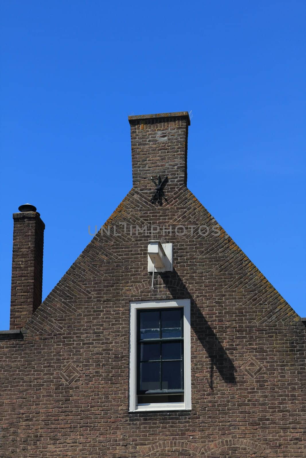 The gable of an apartment building, blue sky in the background