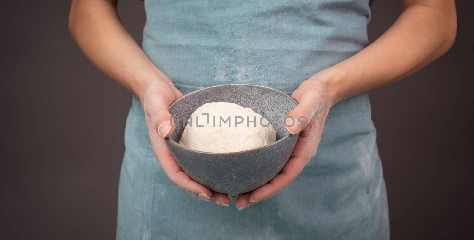 Fresh wheat dough, baker holds bowl with flour, bread or pizza, prepare ingredients for food, baking pastry