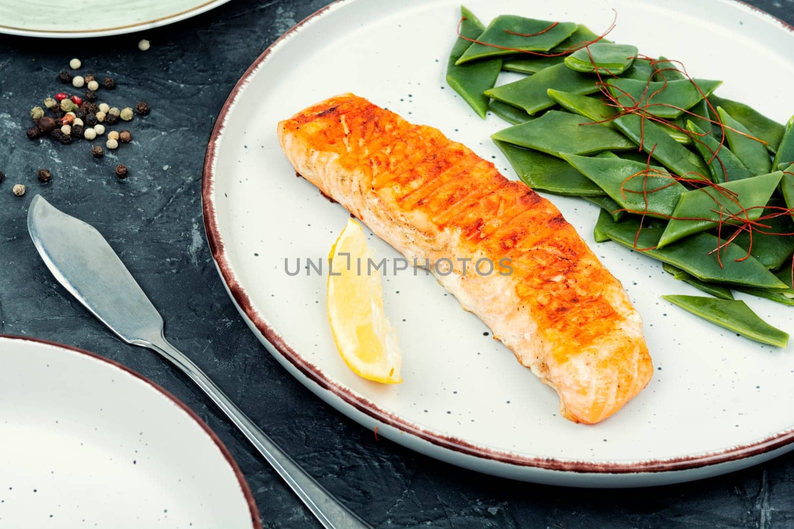 Seared salmon steak with green bean on rustic wooden table. Copy space.