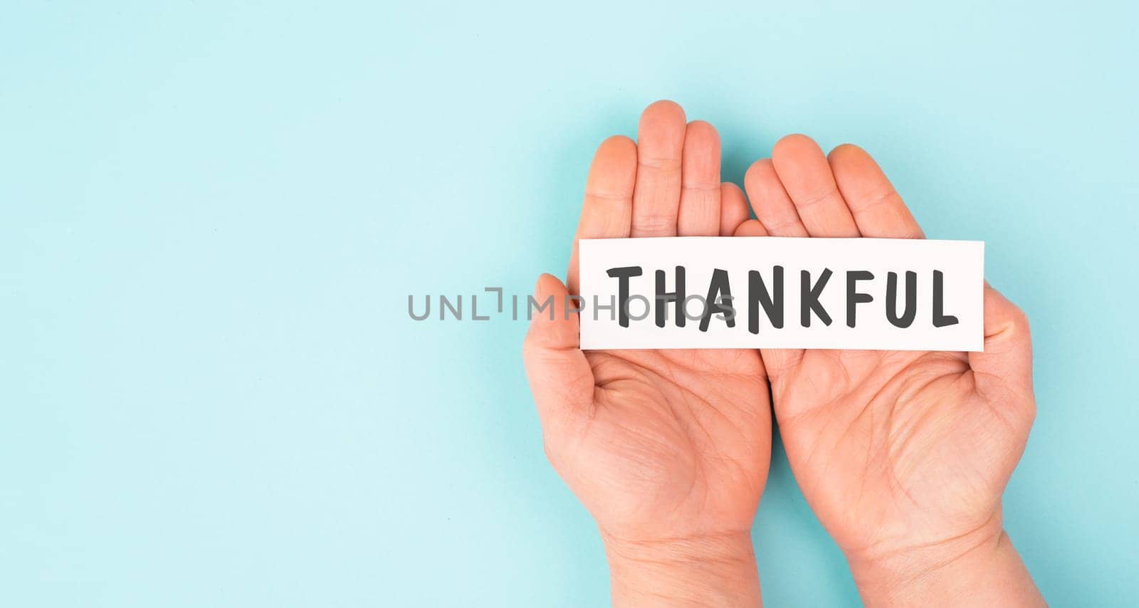 Thankful sign in hand, thank you, support, help and charity concept, positive attitude