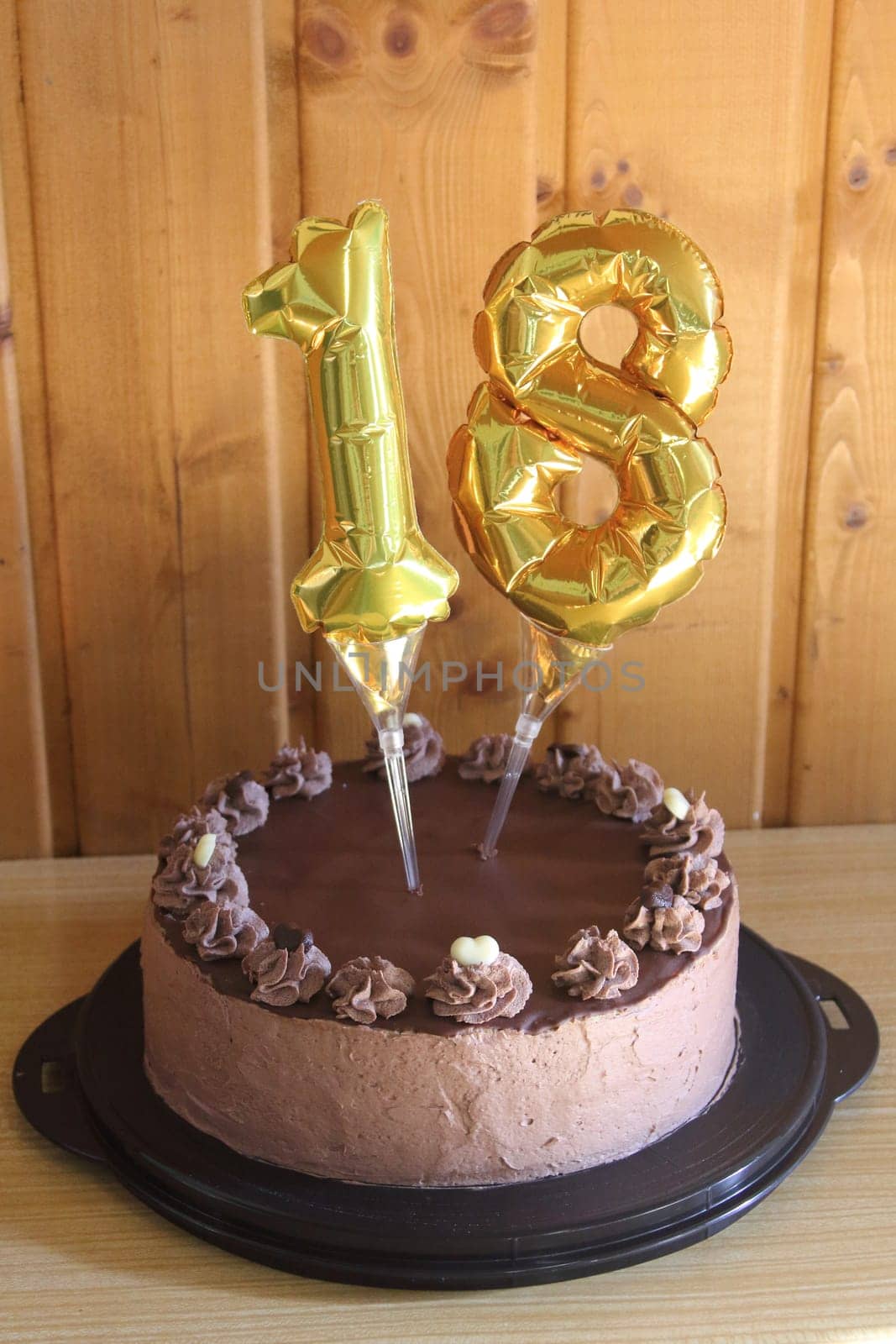 A round chocolate cake with embellishments and an inscription