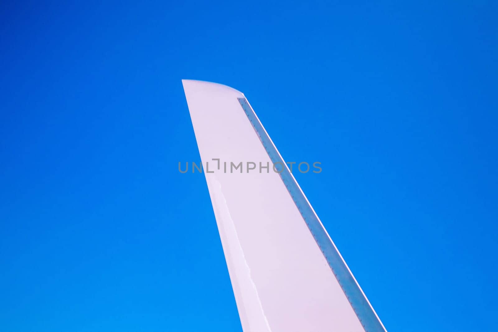 View at the part of a wing of the airplane or airliner during the flight from the window with blue sky and without clouds.Wing of aircraft. Copy space.