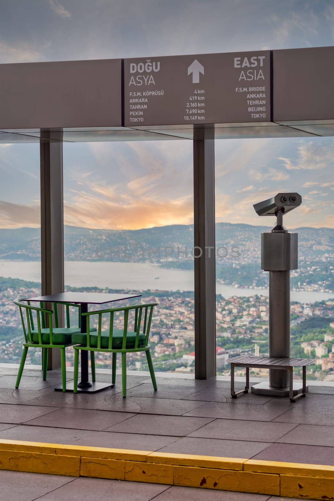 Tower Optical coin-operated binocular on the observation deck of Istanbul Sapphire,Turkey, against cityscape before sunset with sign including distances to some Asian capital cities to the east