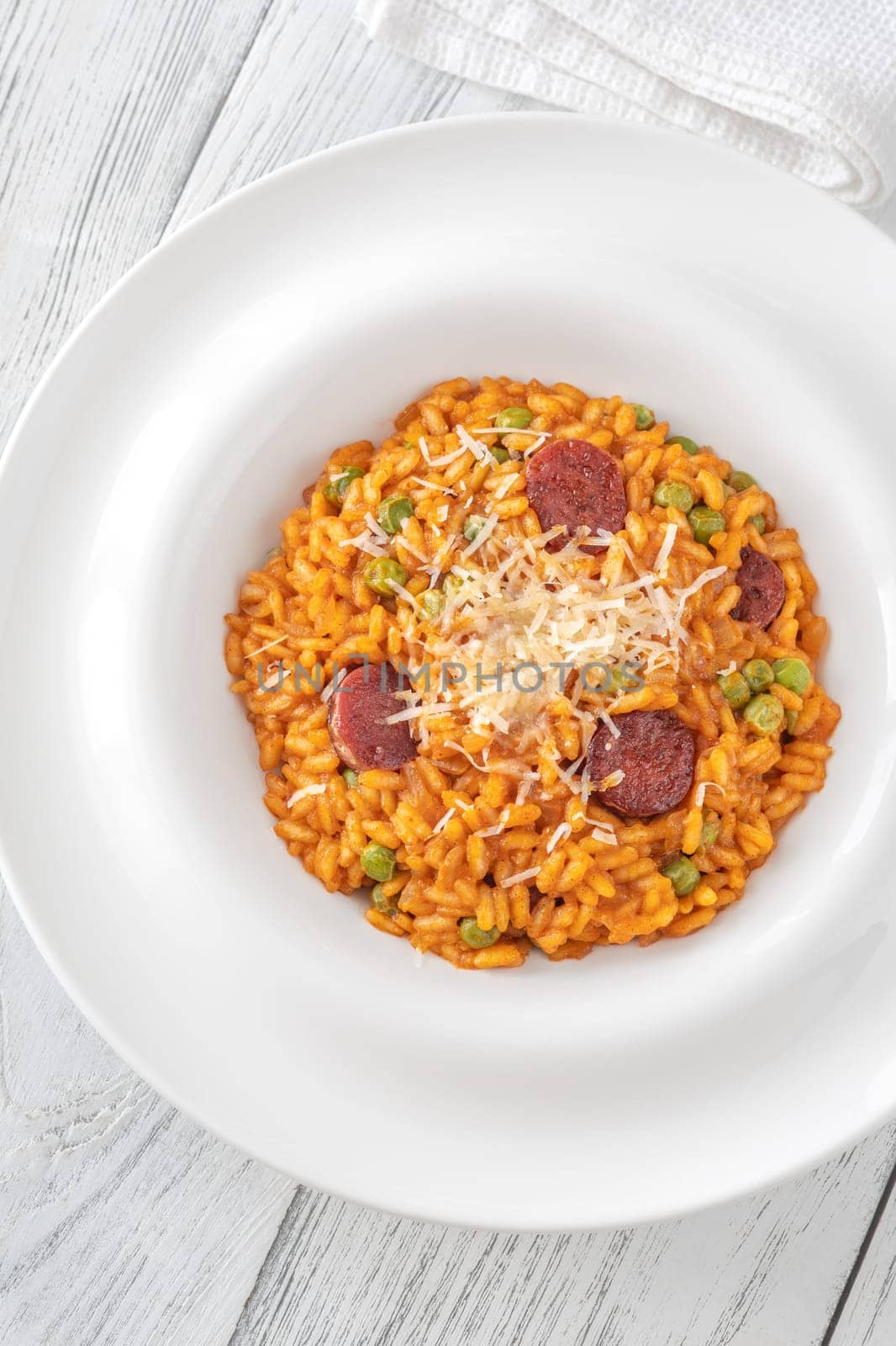 Portion of risotto with chorizo sausage and green peas
