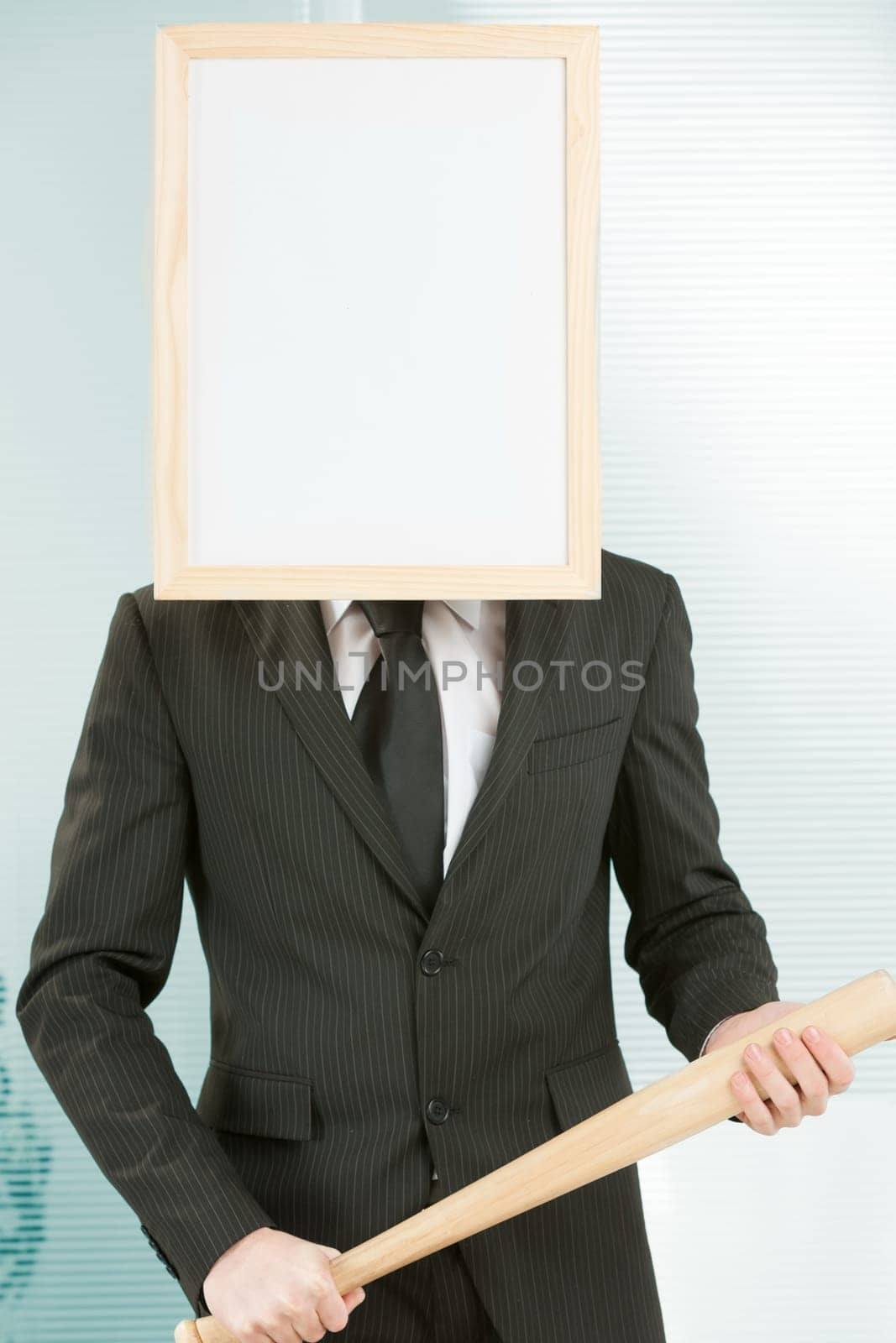 Sign-headed man framed in an office, standing and holding a baseball bat in a threatening manner. He appears to be ready for violent and negative actions. Concept of punishment or threat and aggressiv