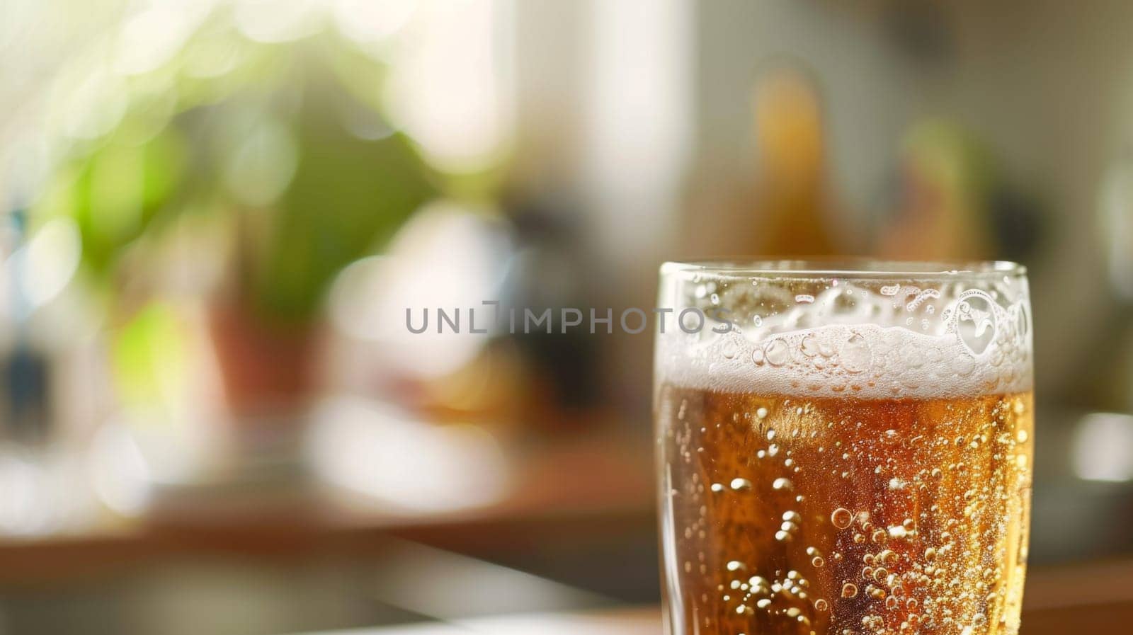 A glass of beer sits still on top of the wooden table, condensation forming on the cold surface. The amber liquid inside the glass reflects the light, creating a warm glow in the room.
