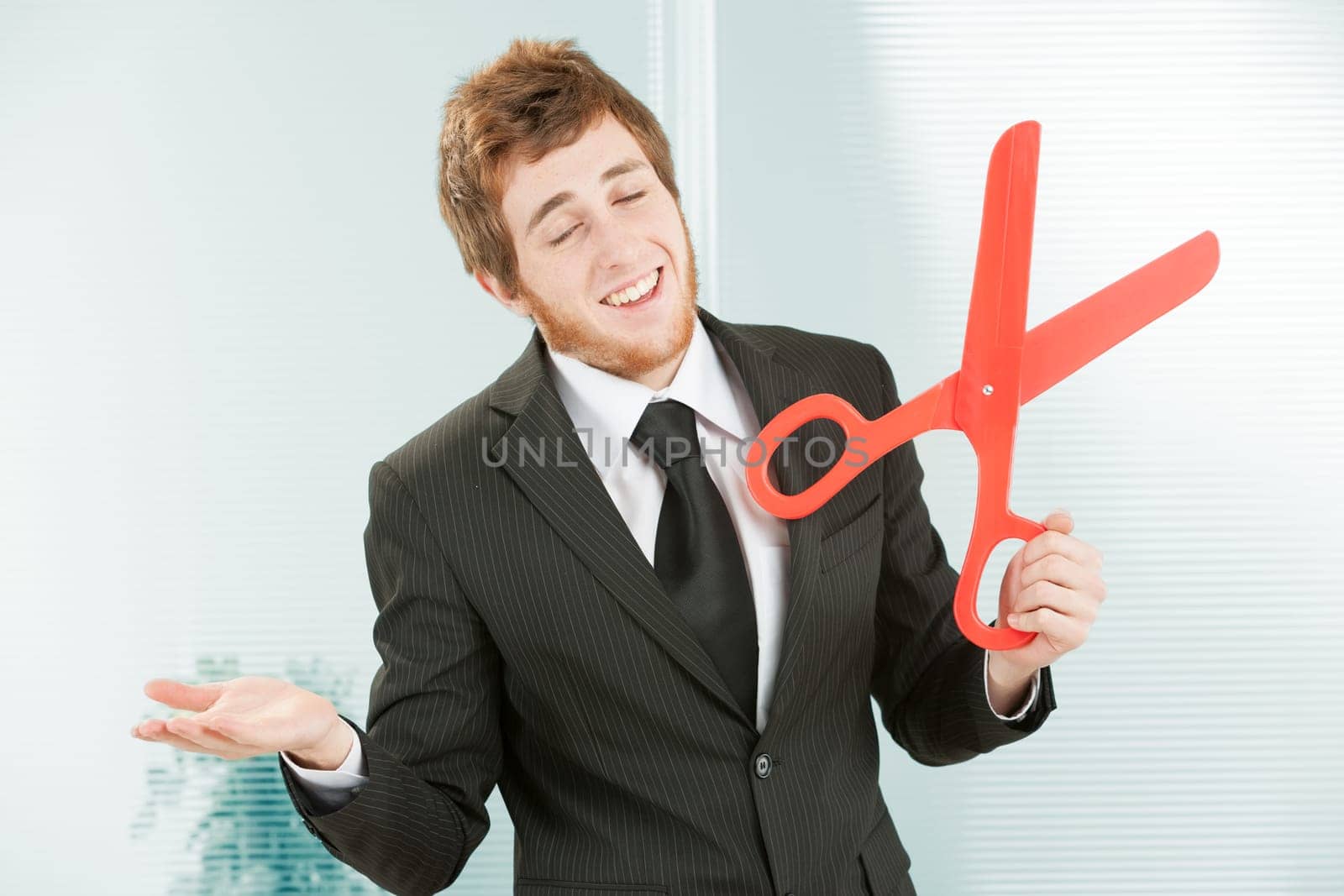 Employer with one scissors in one hand and the other open palm up in a gesture that means 'eh what can you do, my hands are tied, I can't do anything else, I'm forced, these things happen, life is har
