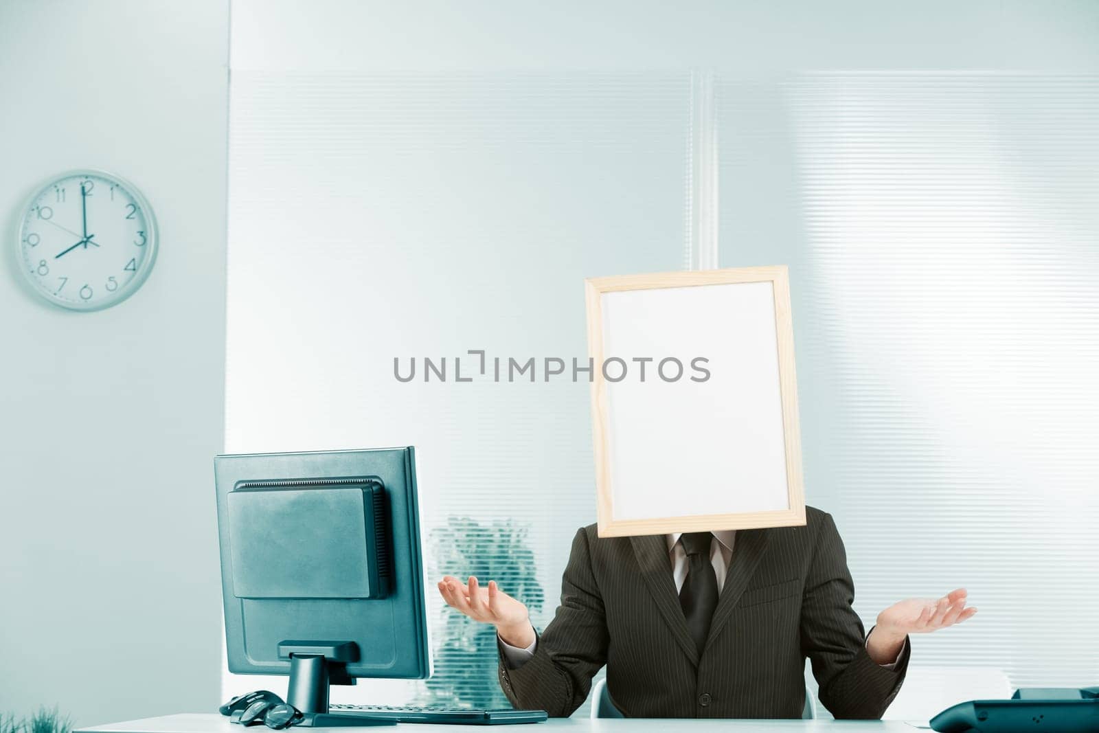 Helplessness, no help, stasis, bureaucracy, wait-and-see, obstruction and uselessness, conveyed by a man in an office with a sign for a head and a posture with his hands open palm up that intends to s