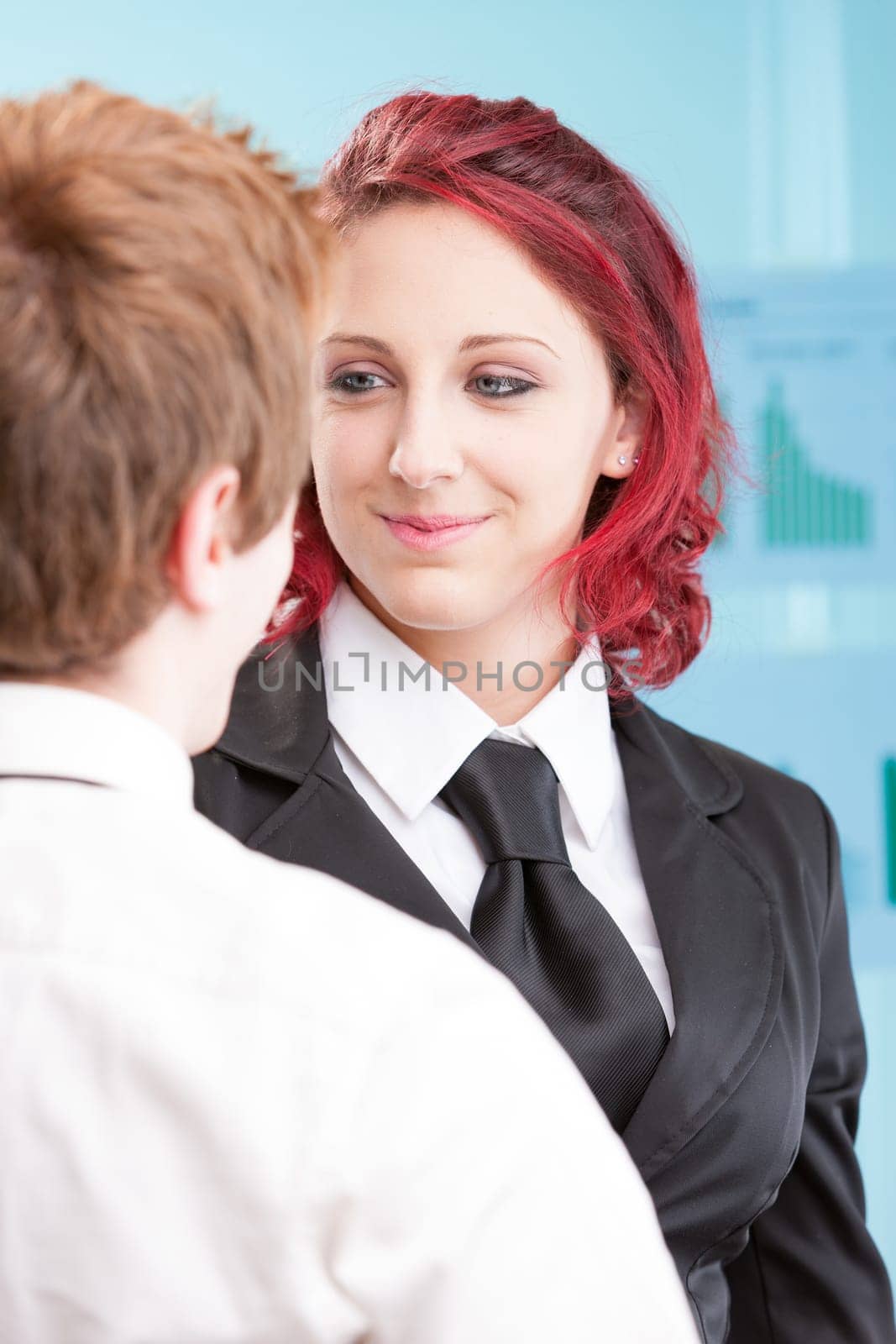 Amid office desks, two young colleagues share a romantic gaze. Love doesn't recognize business hierarchies. Their humanity supersedes any job title