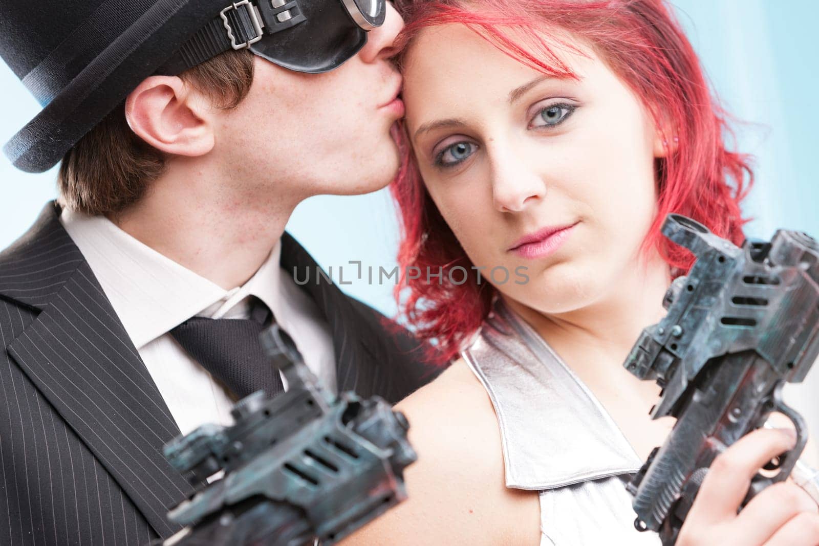 Two worlds collide in a kiss: the bowler hat-wearing superhero spy and his stunning fantasy heroine in silver. With ultrax ray weapons in tow, they find love amidst their action-filled escapades