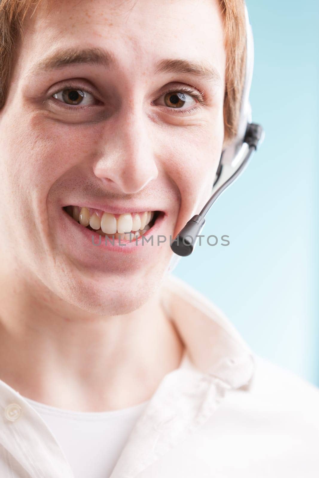 Call center worker in white shirt, amidst blurred background of productivity charts. The real face