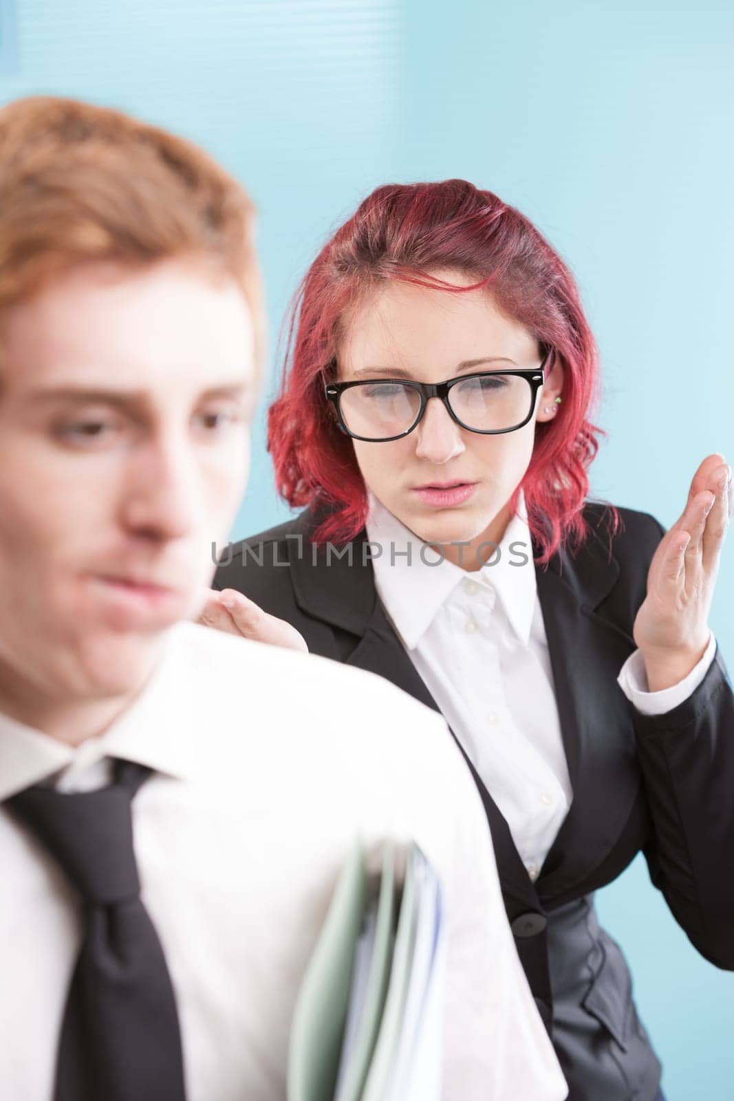 A woman showing inappropriate anger towards a male coworker. Workplace bullying is an issue