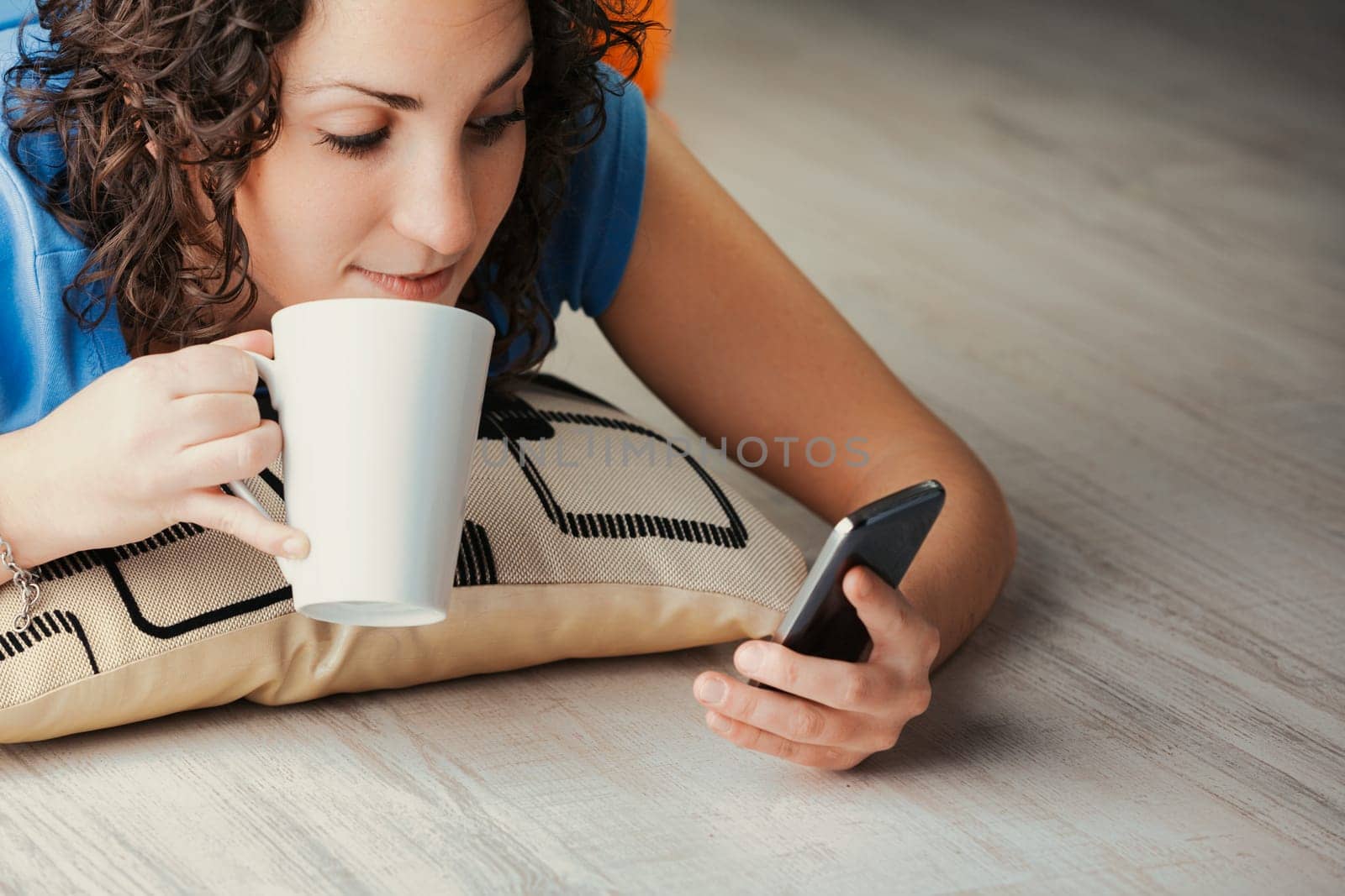 From her home's cushioned floor, a young curly woman plunges into a digital adventure via her phone. Socializing, streaming, gaming, dating, or venturing into adult content, she exploits her device's