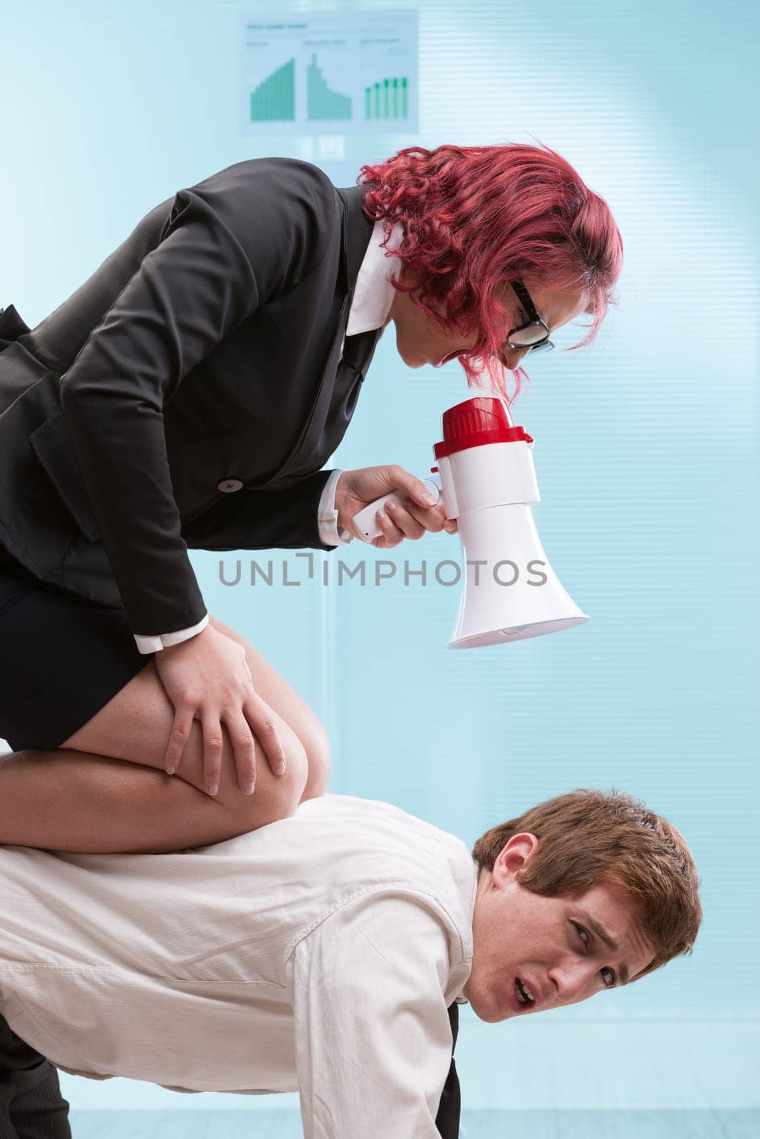 Female boss bullies her male employee, physically subjugating him. A metaphor for wage slavery