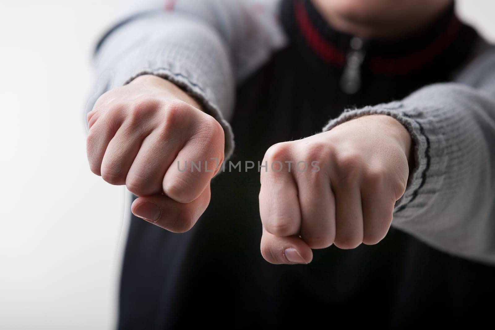 guessing game is depicted in the close-up of a young white-skinned man's hands. Wearing a gray and black sweater, he challenges you to guess which hand, if any, holds an object