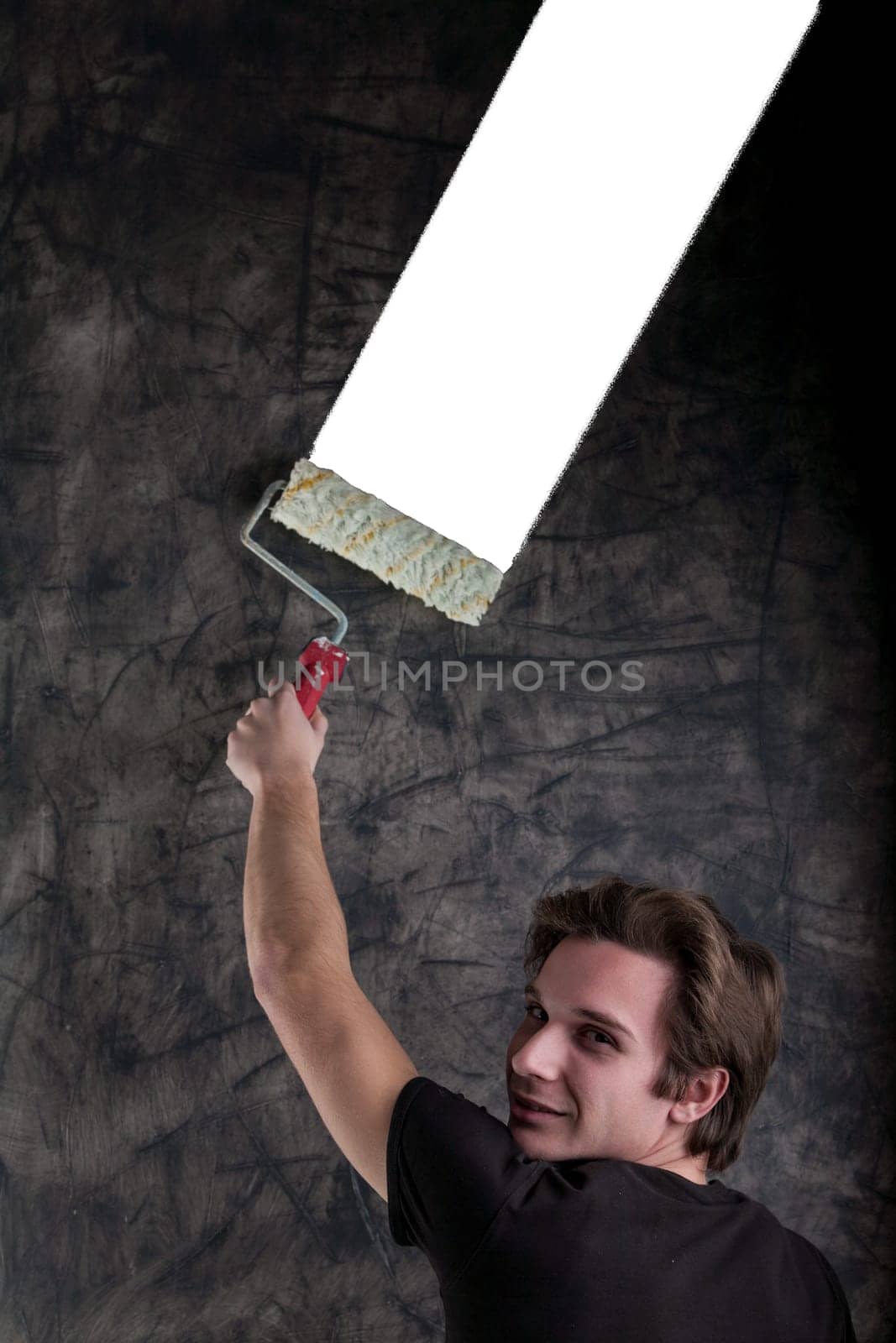 Against a grunge-filled black backdrop, a fine-looking male with a black shirt and light-brown hair strategically rolls a white segment, paving way for COPYSPACE