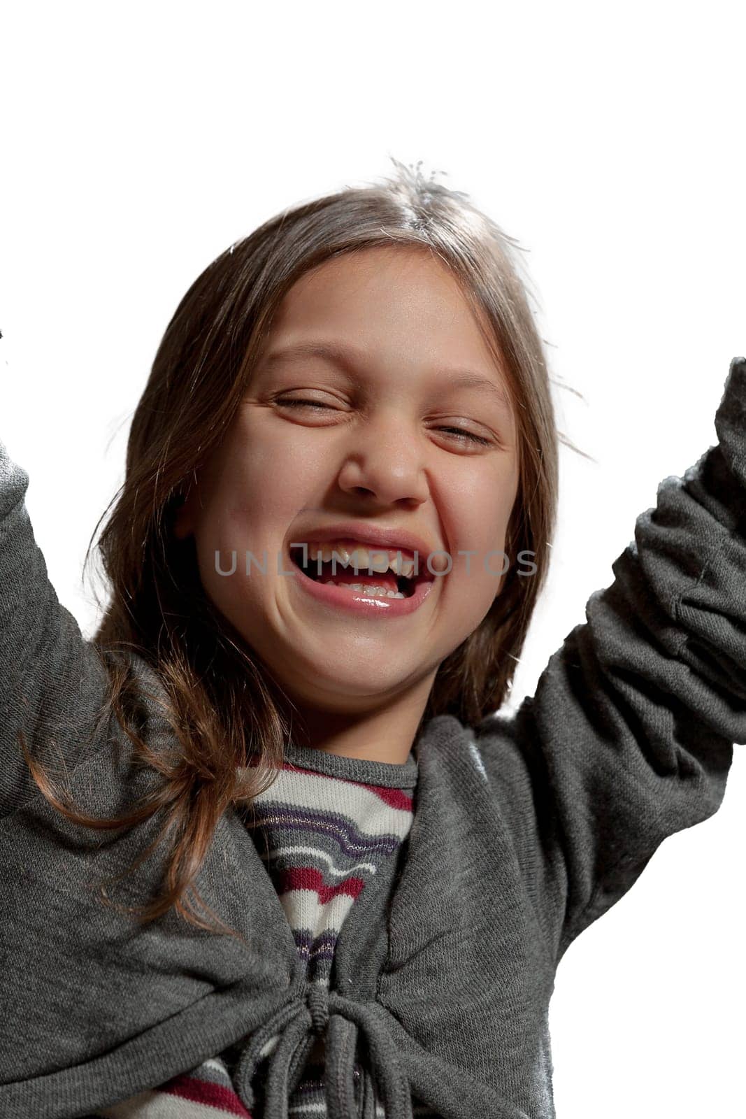 girl exuding joy, wearing a striped top, grey cardigan, jeans and fur boots, set against a white background. Her long hair flowing as she laughs freely