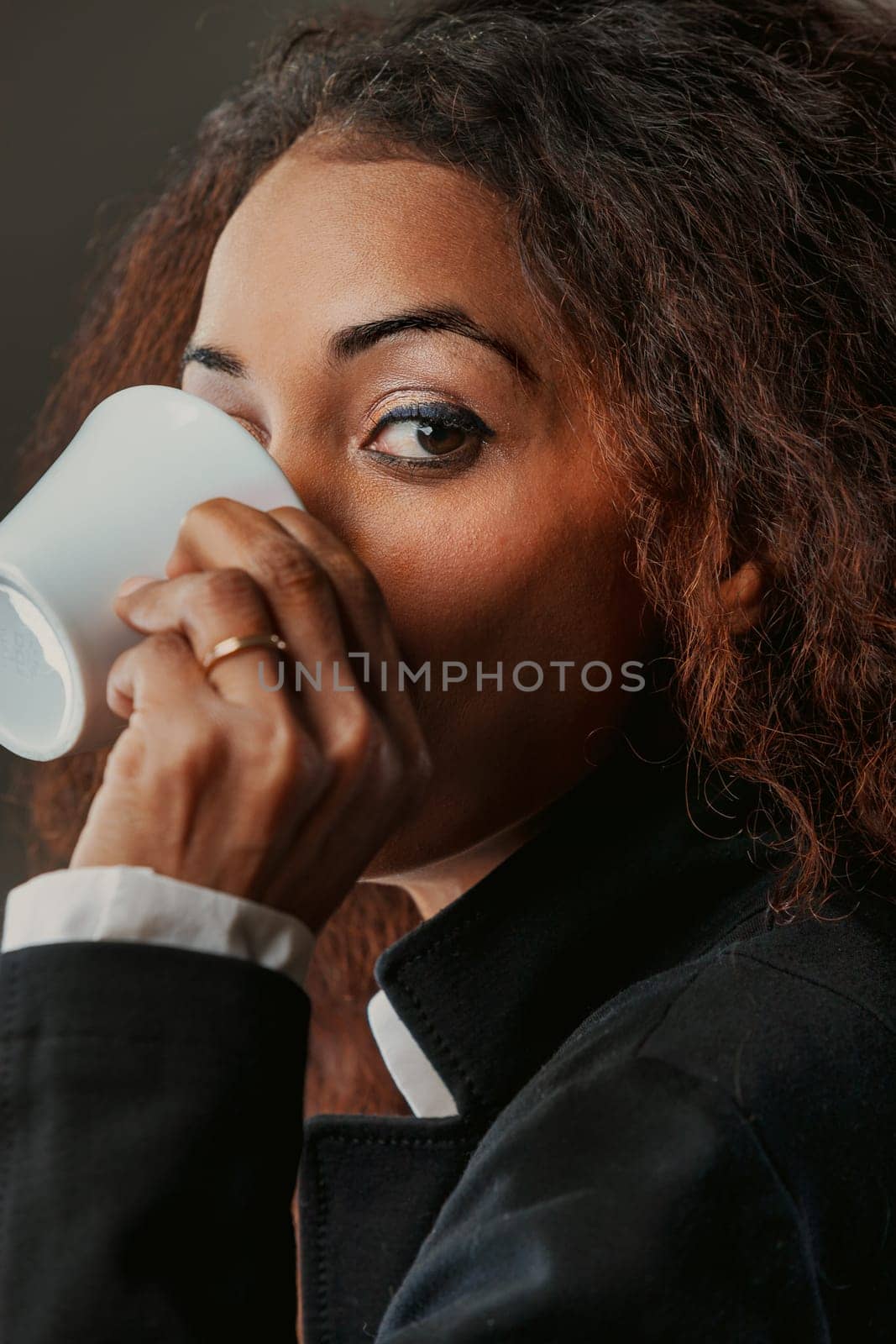 Drinking her espresso, a striking black woman's gaze holds power. In business and high society, she's a force, knowing that with knowledge comes choice, and she embodies freedom through choice