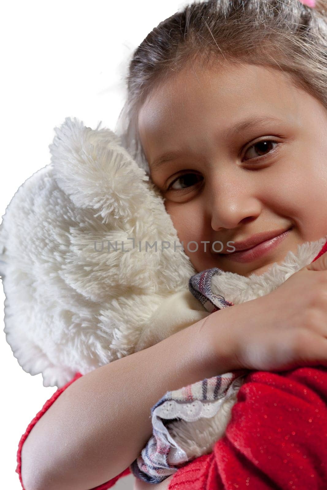 Girl in a red sweater loves her white teddy bear, plays with it, cuddles, hugs, throws. Her playmate, reassuring, soft and loving