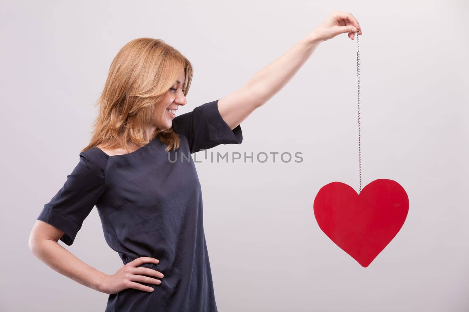 Elevating a symbolic heart, a woman conveys cardiovascular health's importance. Recognizing the role of diet, blood pressure, and vein upkeep, she understands that life's essence allows for romantic e