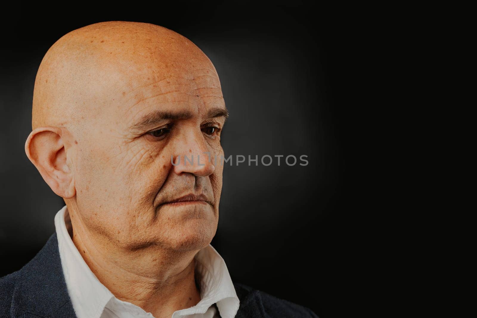 Depicted beside vast COPYSPACE, a bald, dignified elder in blue ponders past actions for the planet's future. He questions the sufficiency of his legacy for the well-being of his lineage