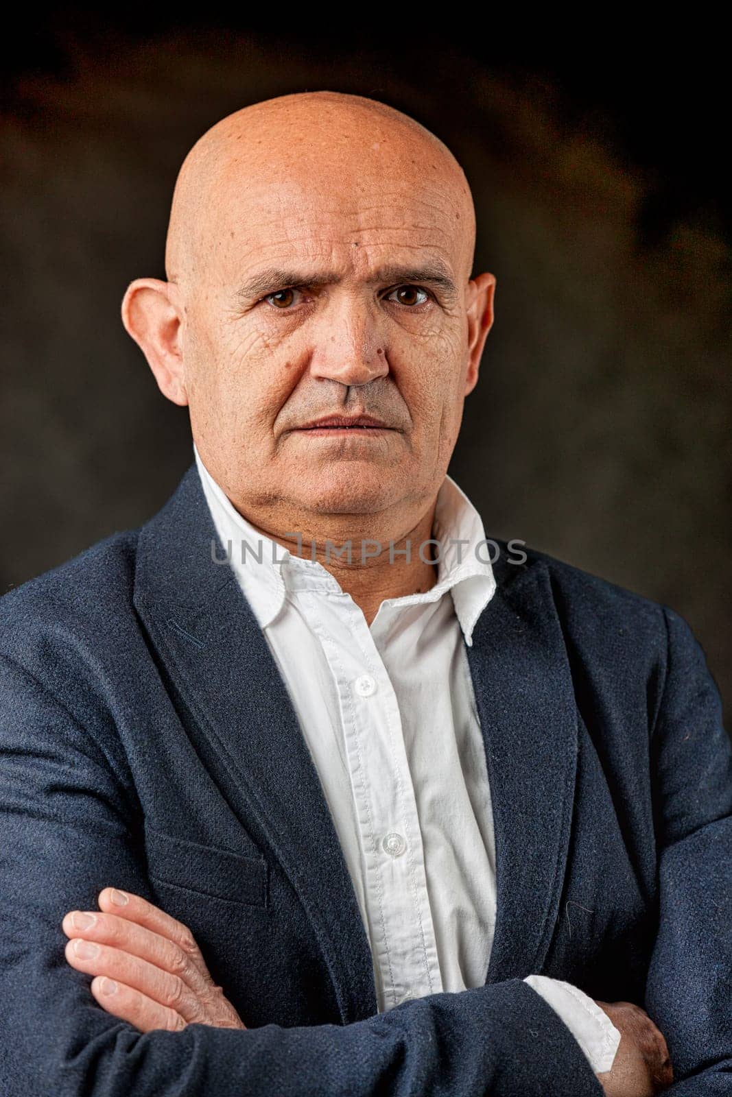 In formal attire but with a sporty open collar, a balding older man's portrait radiates disdain. He perceives young people as weak, recalling his own daring youthful feats