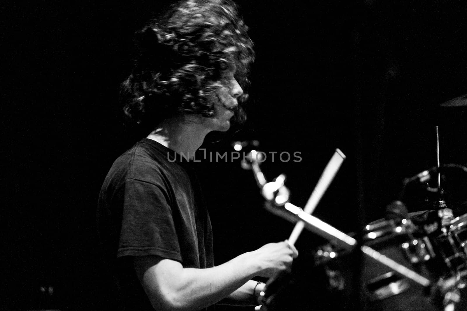 Live stage performance: drummer, adorned with dark makeup, strikes with the energy and speed of a rocker, showcasing the art and technique of passionate music