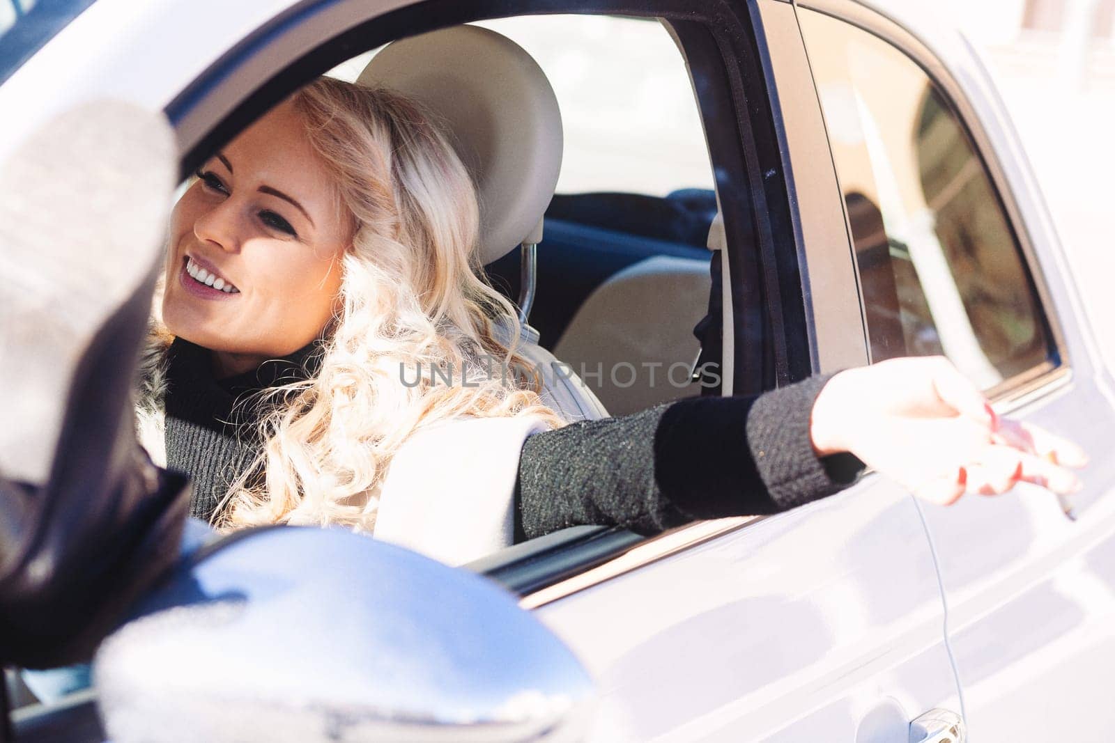 Blonde girl in a car is a tourist with long hair, smoking a cigarette to emulate a pop star while enjoying her European vacation. She loves solo travel, never knowing who she'll meet along the way, ce