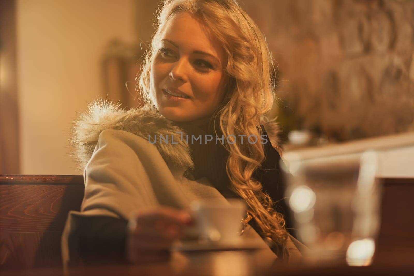 In sunlit European haven, young wanderer sips espresso's soul. Winter's chill forgotten wrapped in fur, beauty radiant. Solitude embraced, yet open to serendipity