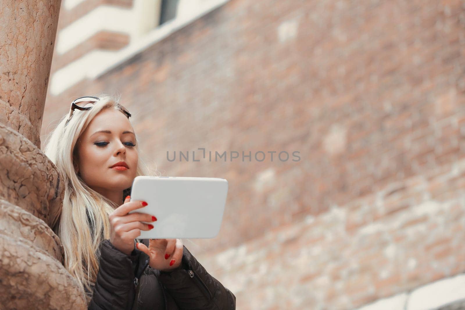 blonde tourist, lacking preparation for her European adventure, finds her way using a tablet. She relies on internet resources for maps and guides, feeling less uninformed and enjoying her travels