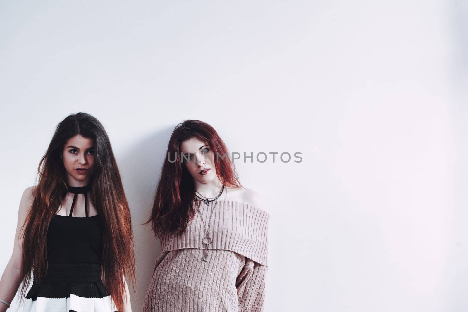 Captured are friends: one in effortless glam, the other in a two-toned dress. Their chosen attires, makeup, and poses exude a beauty they enjoy while it lasts
