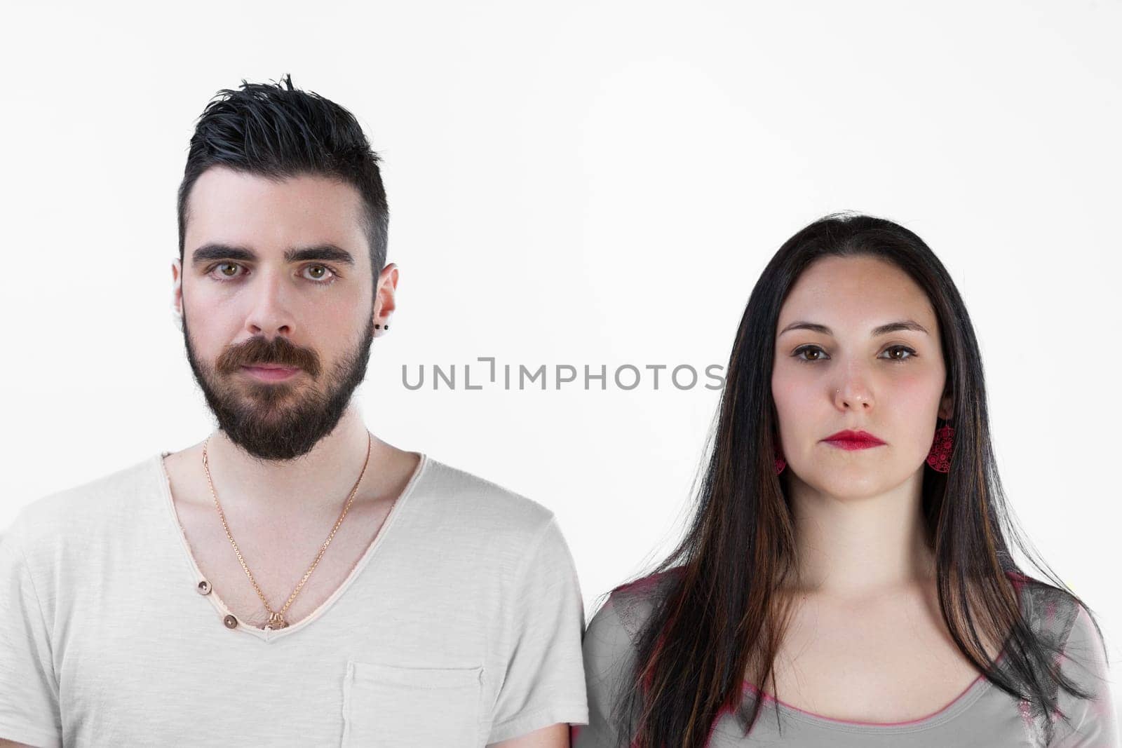 Frontal view of a man and woman, side by side, their expressions blank or sad. Relationship in question or crisis, communication issues? Simply suffering life's blows together. He's bearded, she with