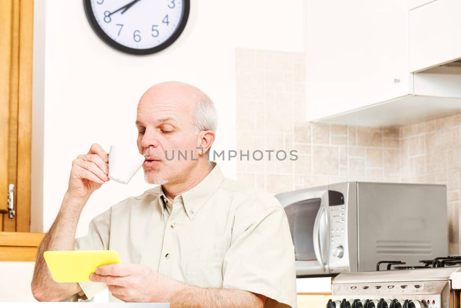 During breaks, senior engages with smartphone, tablet. Reflecting older generation's deep appreciation for tech, he earnestly navigates, yet grapples with separating dependable from spurious content
