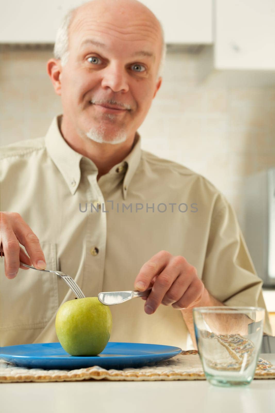 Elderly man, staring at a sole green apple, shows amusing reactions. Deep down, he detests his diet, yearning for flavorful, fatty, and sweet meals. But a stark medical caution stands: those choices s