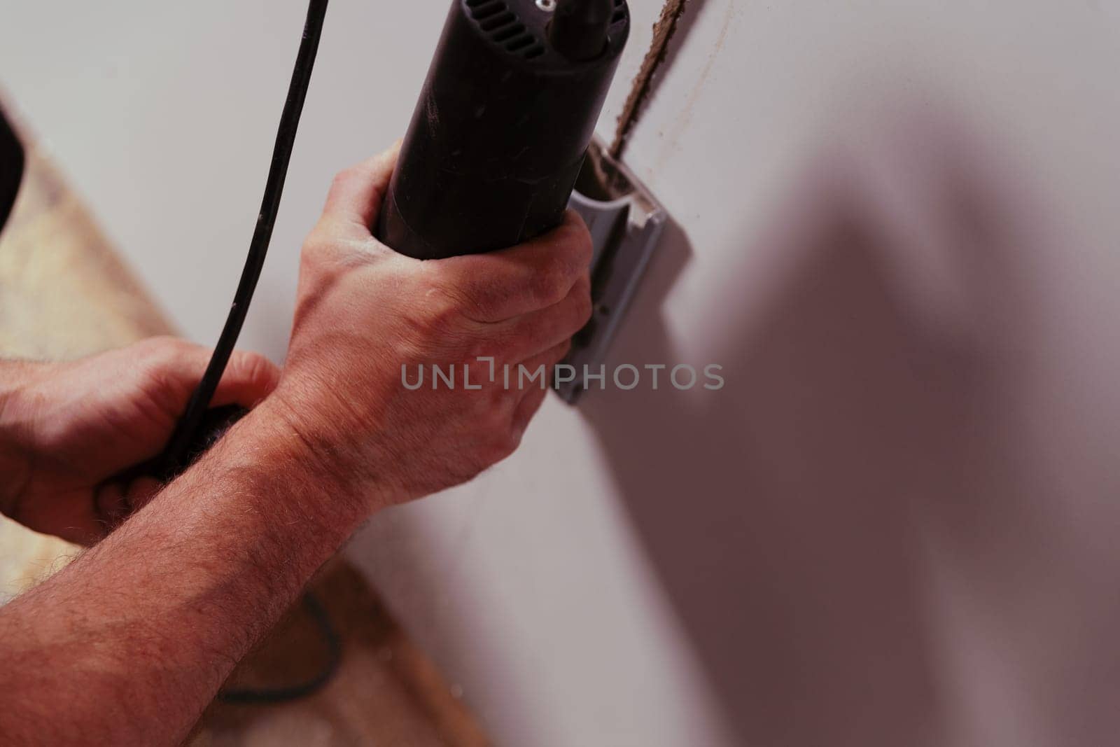 Strong carpenter's hands using a cutting tool in his craft workshop. The forearms are also powerful and hairy. His work is precise and somewhere between art and craft.