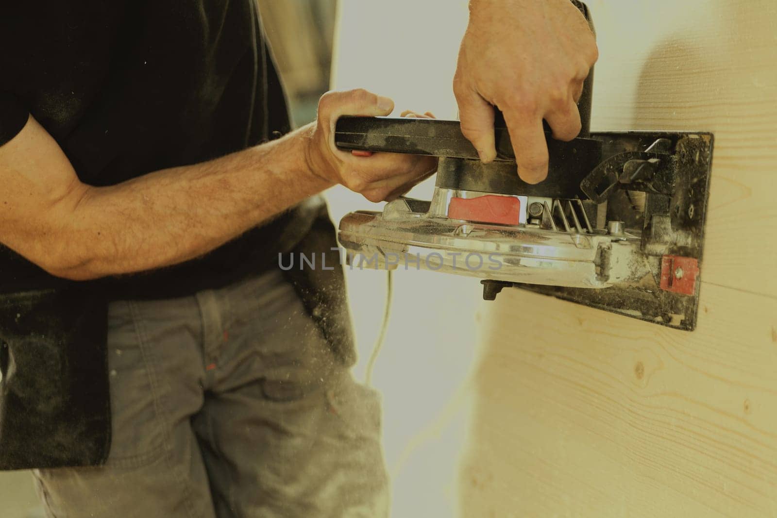 Man in action at work with powerful tools. Carpenter is sanding a wooden surface. The old planers are no longer being used.